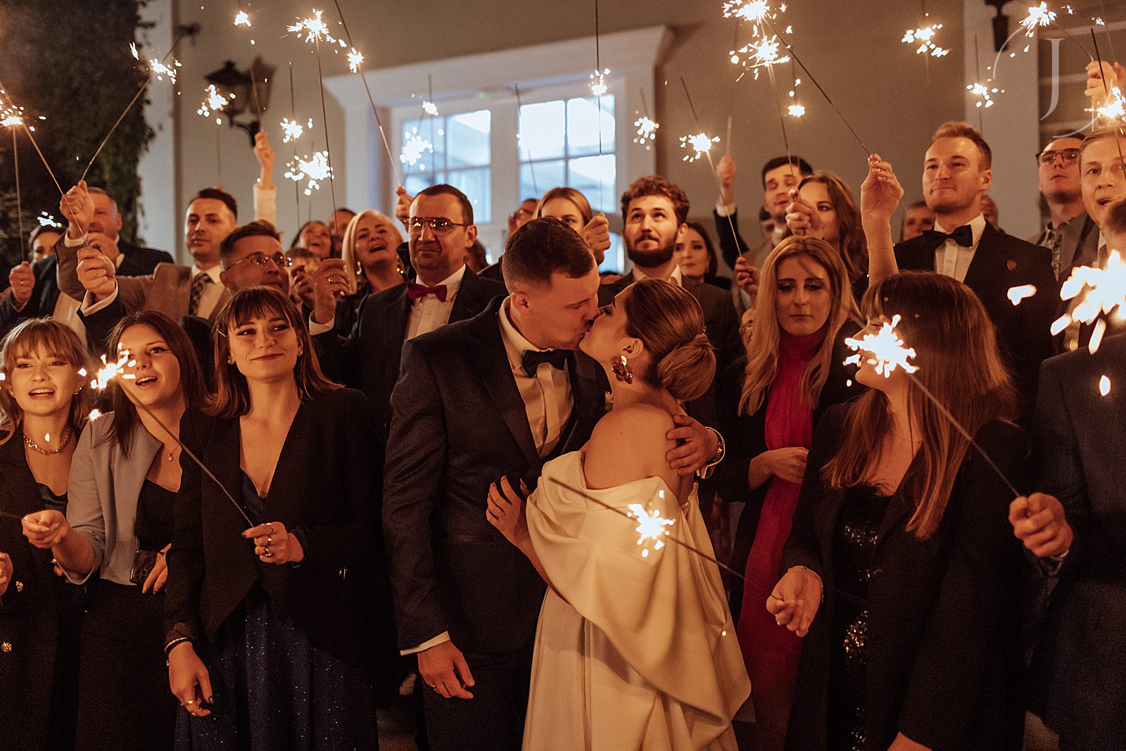 Zdjęcie Pary Młodej i gości weselnych ze sztucznymi ogniami.