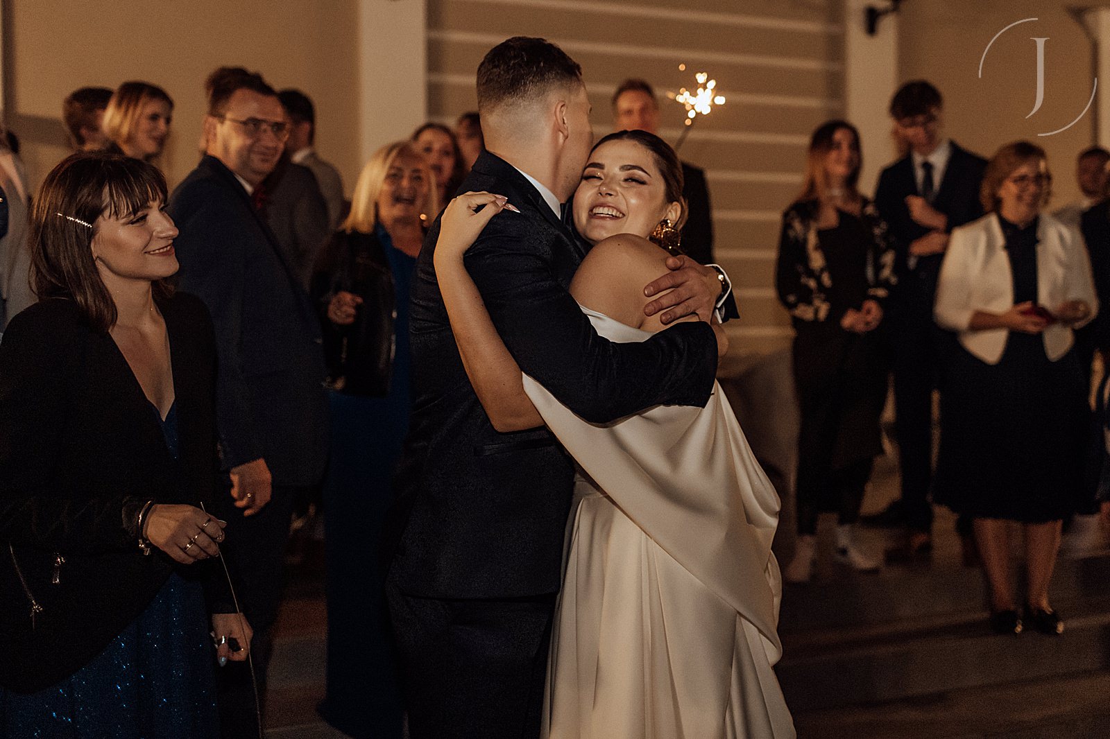 Zdjęcie Pary Młodej i gości weselnych ze sztucznymi ogniami.